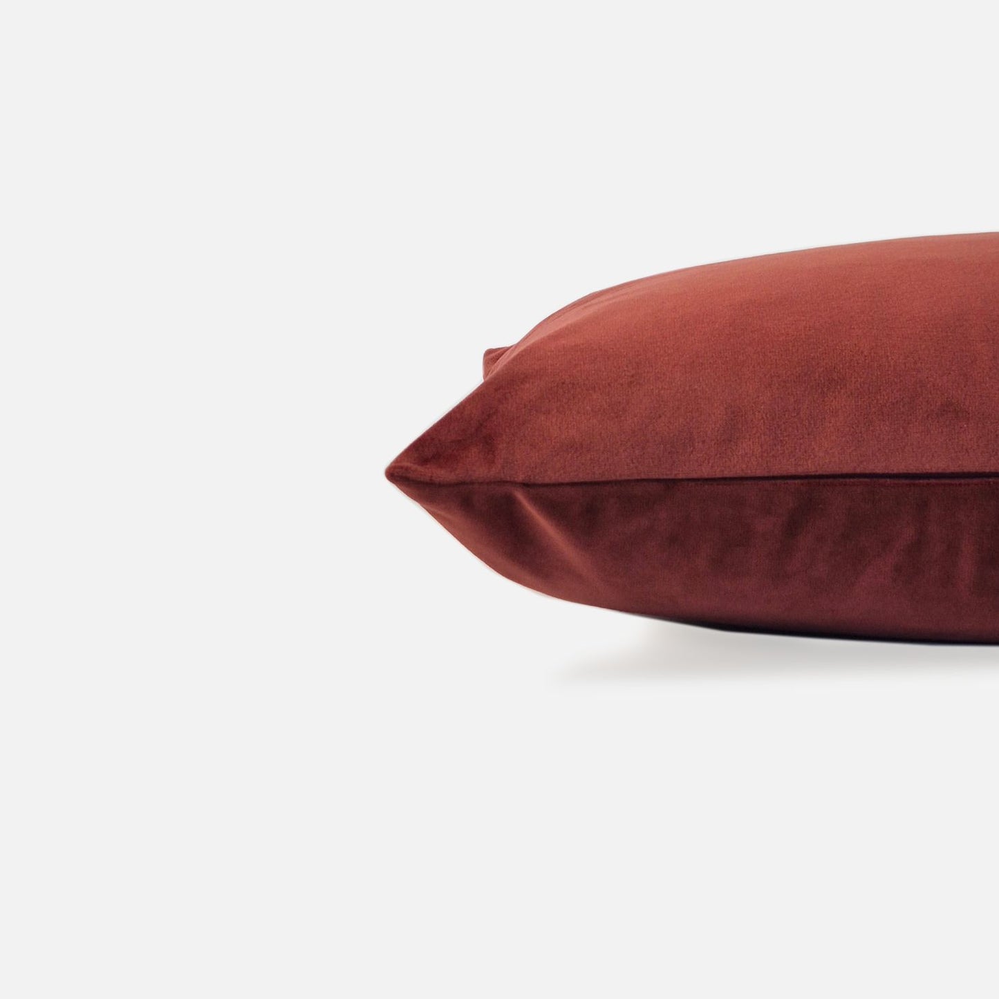 Red velvet cushion, side view on a white background