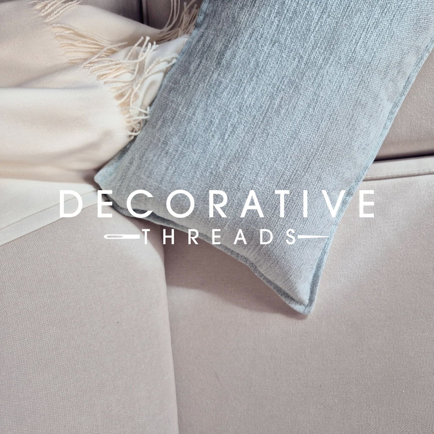 Decorative threads cushion on a cream beige sofa with 'Decorative Threads' logo overlay for E-Gift Card.