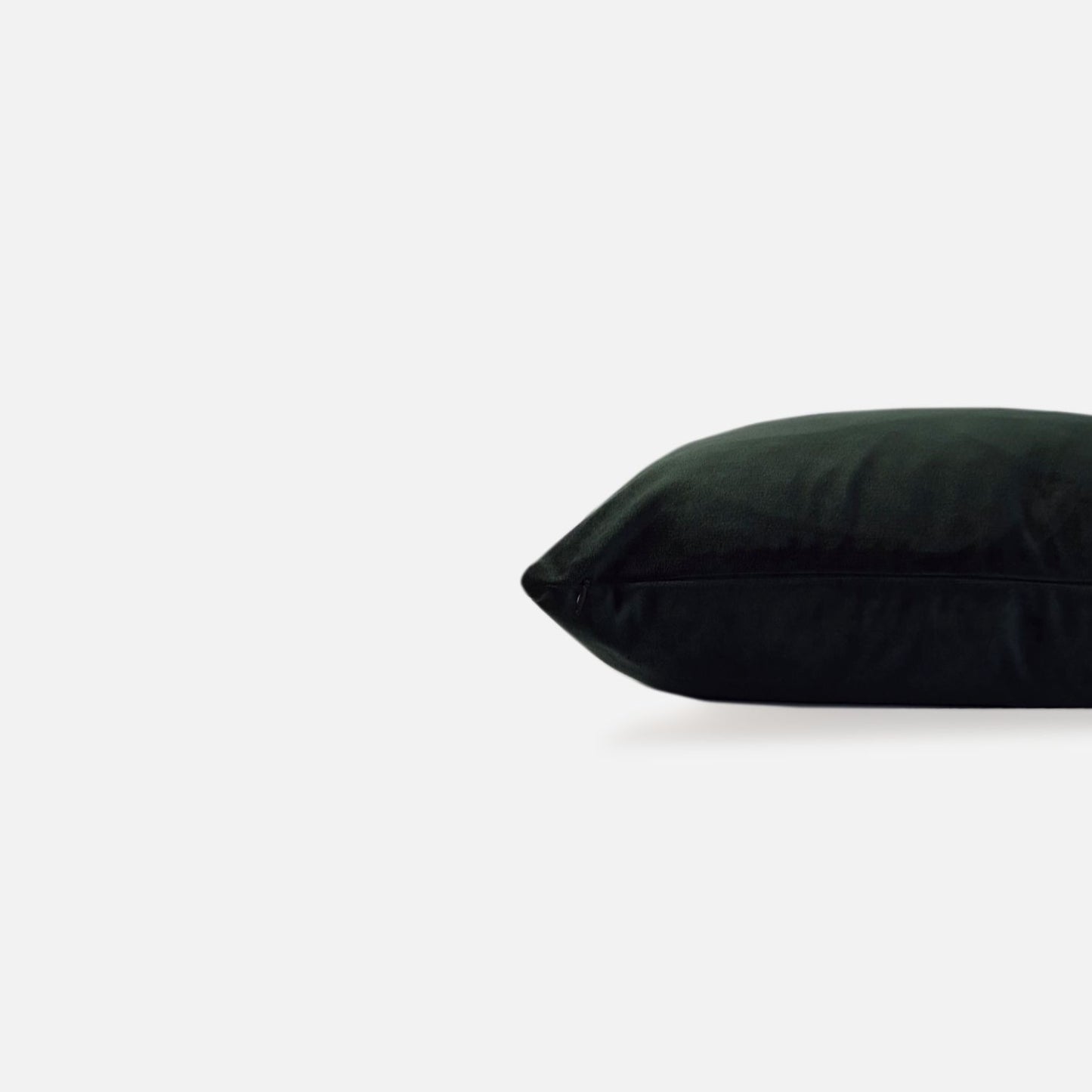 Decorative Threads Dark green, emerald velvet cushion, side view on a white background.