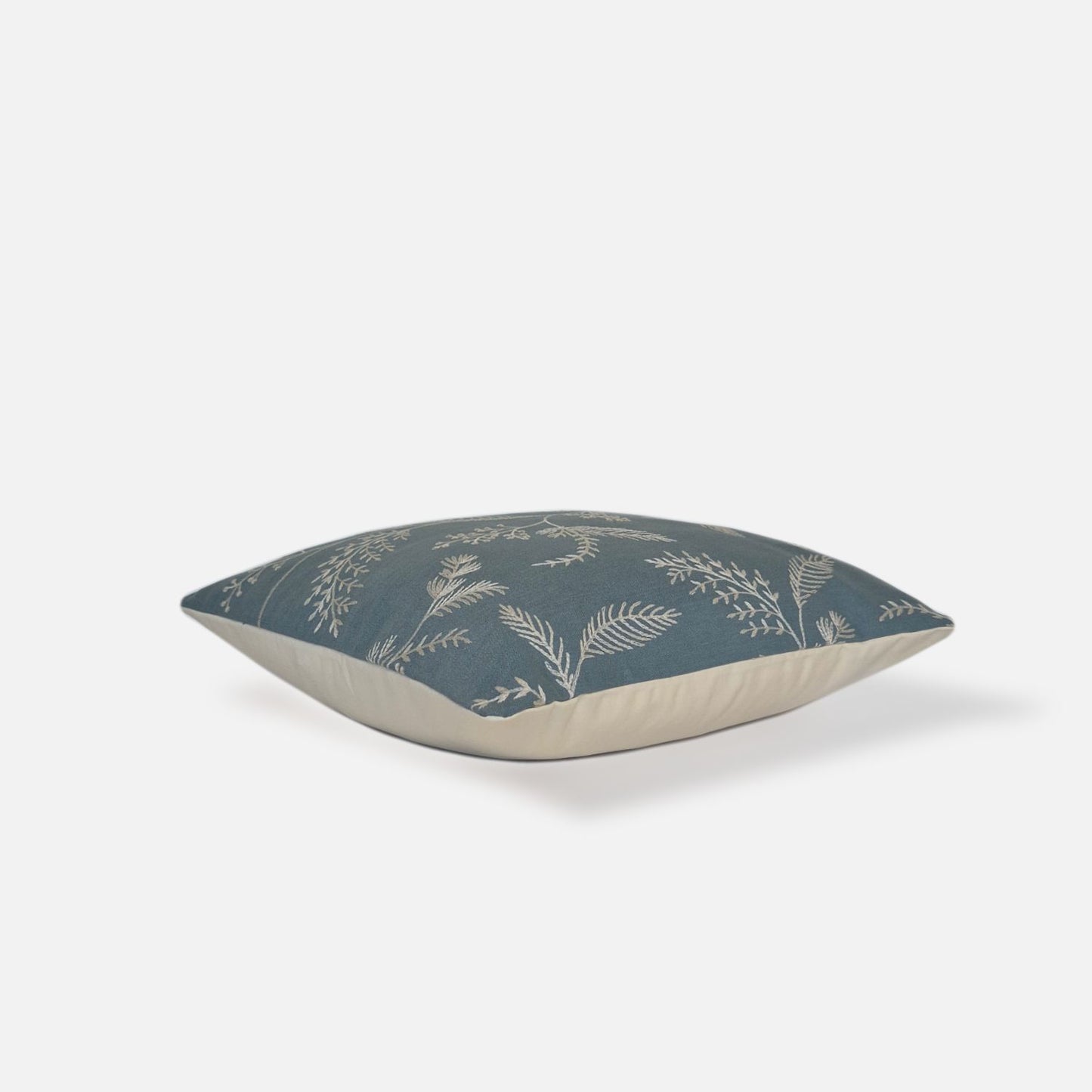 Decorative Threads Medley cushion cover in dusty turquoise with a embroidered botanical design, top view on a white background