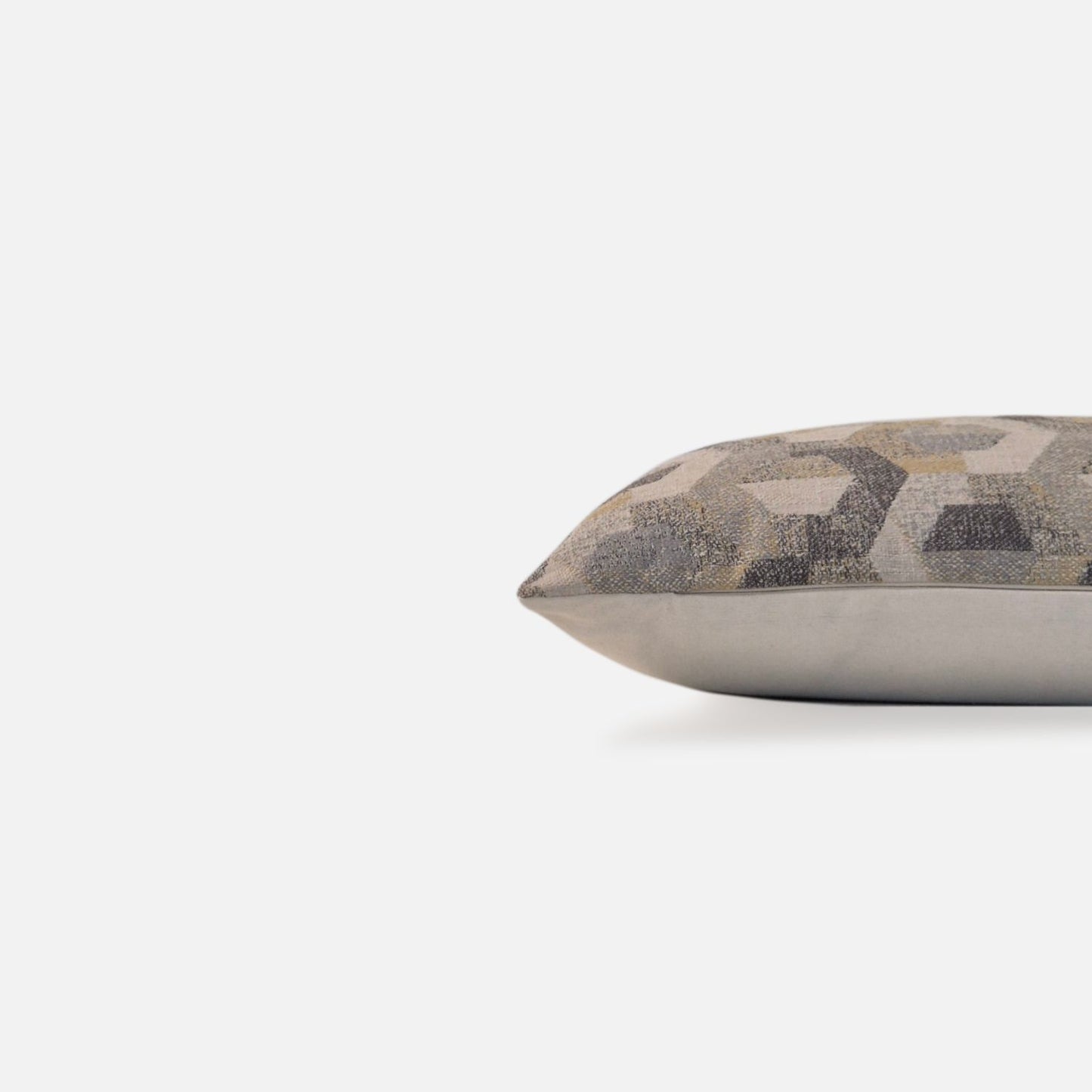 Side view of a neutral geometric cushion cover with woven textured detailing.