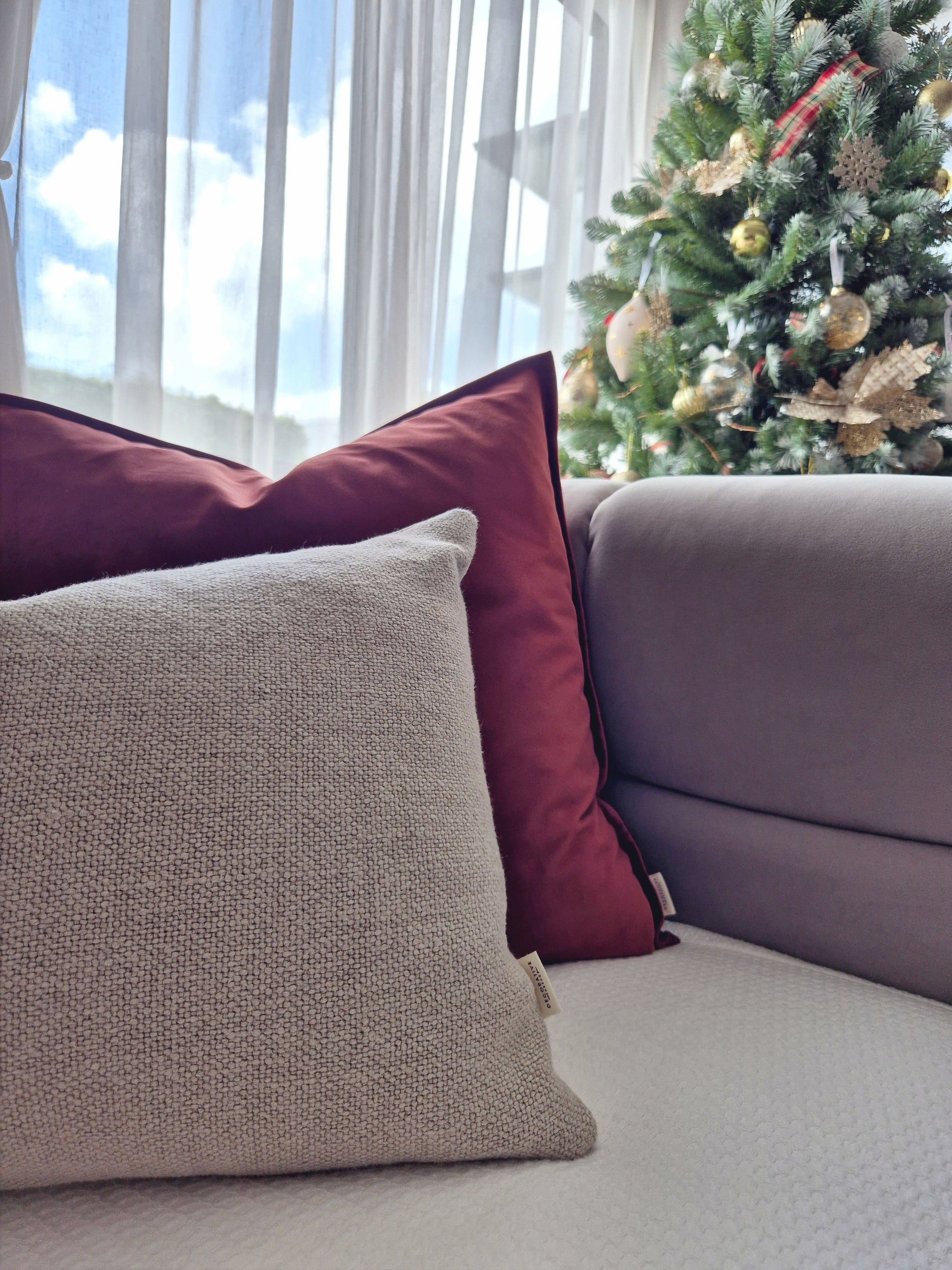 Decorative Threads cushions , Camden Velvet & Linora Line a sofa with a Christmas tree in the background
