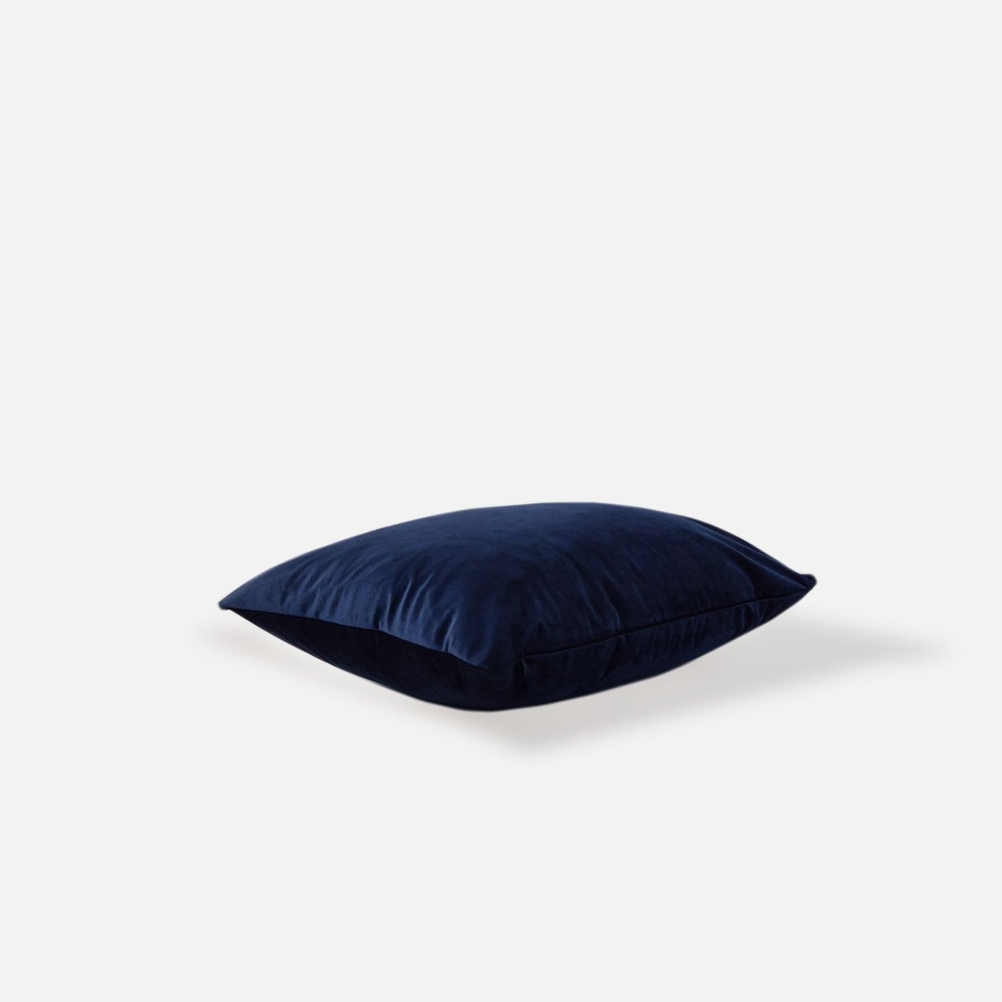 Navy blue velvet cushion on a white background