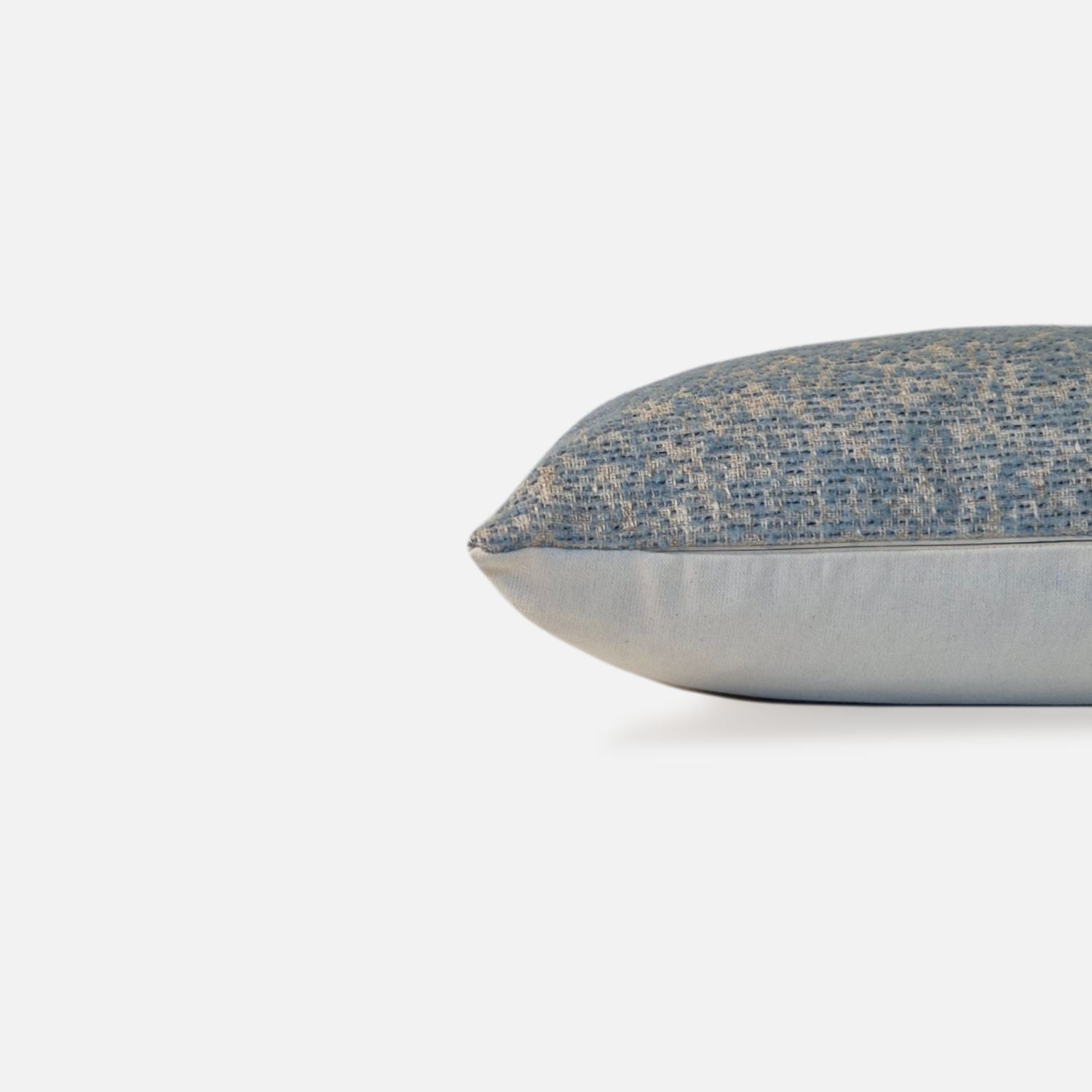 Decorative Threads light blue textured speckled cushion, side view on a white background