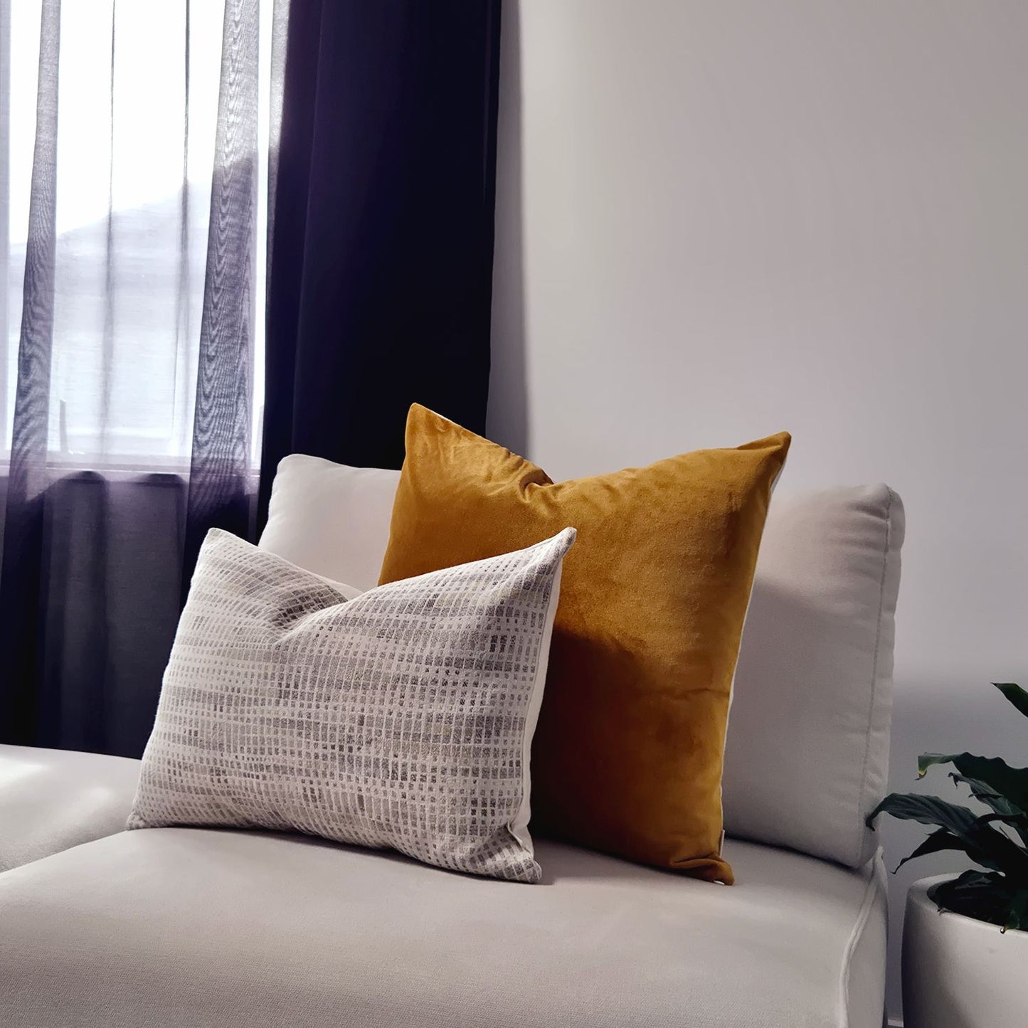 Decorative Threads Geometric Abstract cushion cover combo  on a cream sofa. Luxe duo set featuring rich honey coloured velvet paired with a contemporary abstract weave.