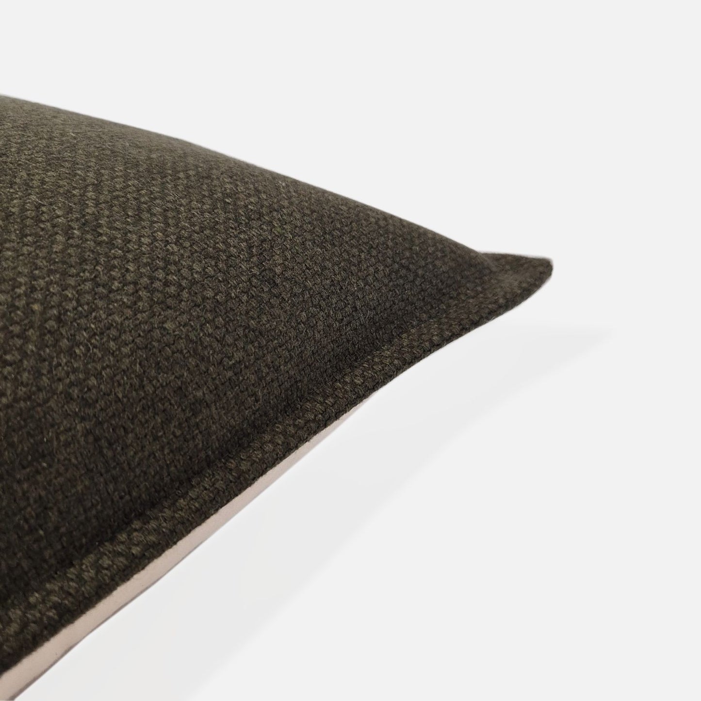 Close-up detail of the Amano Olive dark green woven fabric, showing the high-quality wool-blend texture and durable craftsmanship of the textured cushion cover by decorative threads nz.