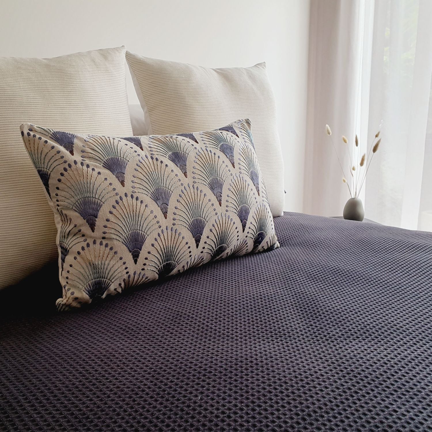 Amelie & Fanciful cushion covers, styled on a bedroom with a black textured duvet