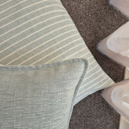 Azure and misty cushion covers on the floor in a bedroom
