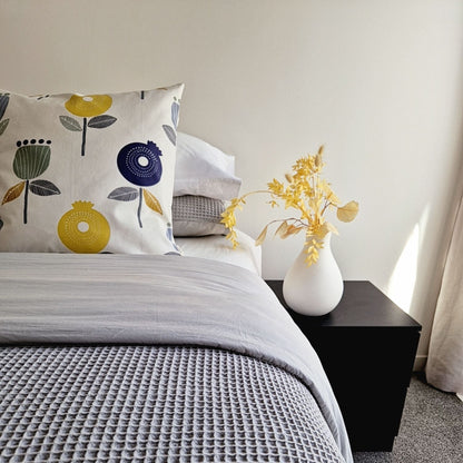 bloom cushion cover placed on a well made bed