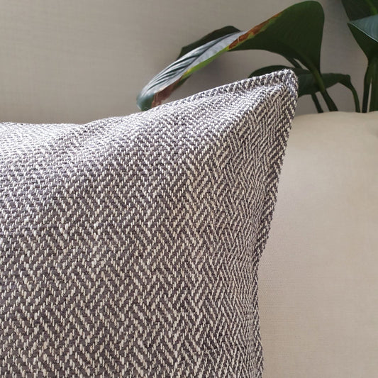 Brunswick cushion cover in colour storm on a sofa in the living room