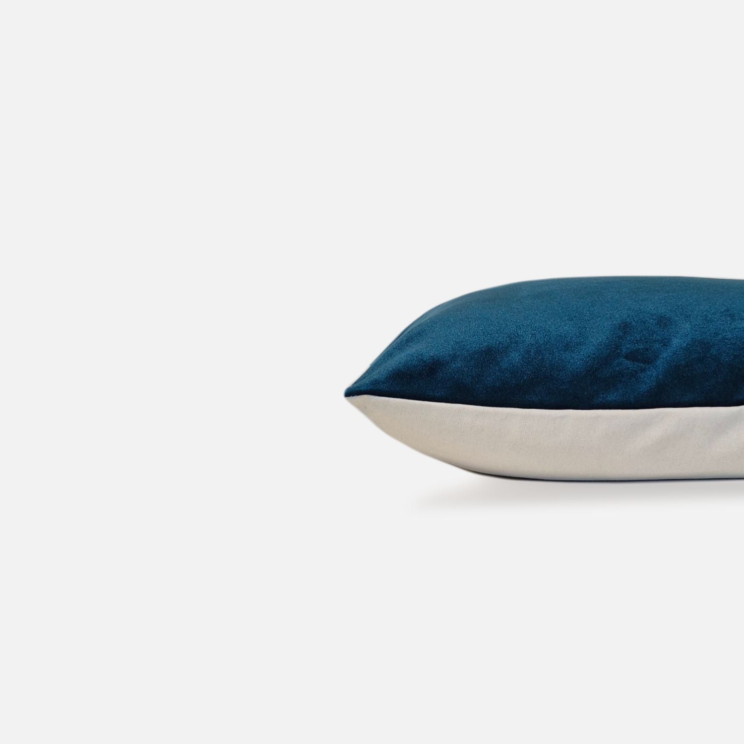 Decorative Threads Peacock coloured cushion, side view on a white background.