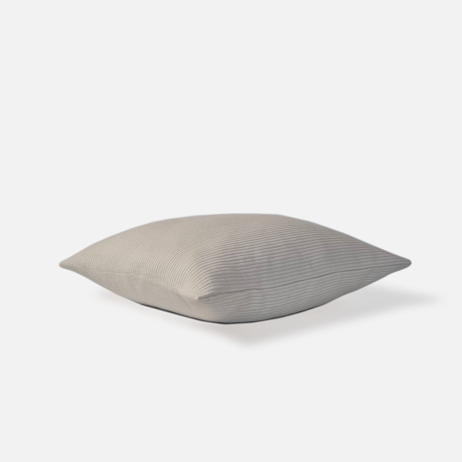 cream textured cushion with ribbed pattern, top view on a white background