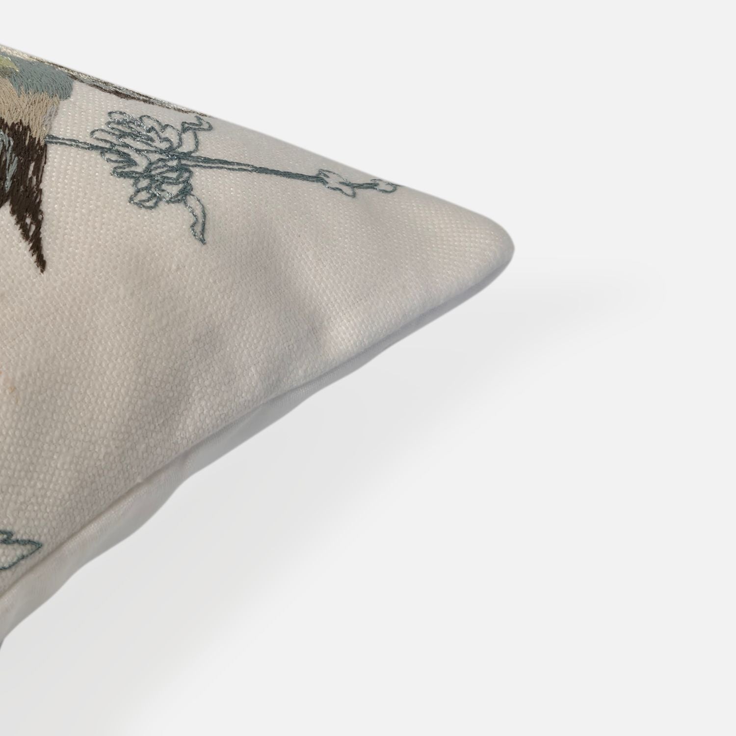 Elysian cushion with bird and plant embroidered pattern, corner view on a white background