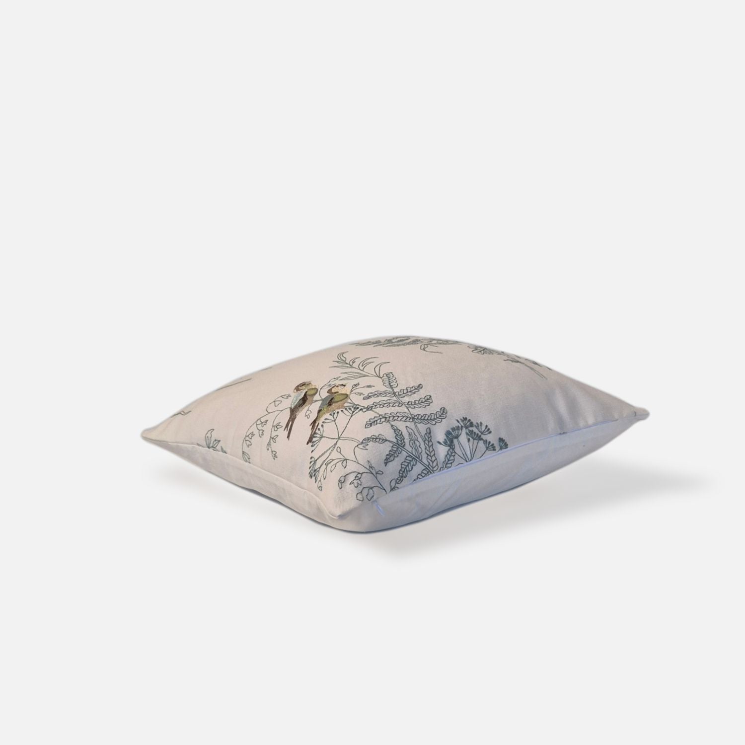 Elysian cushion with bird and plant embroidered pattern, top view on a white background