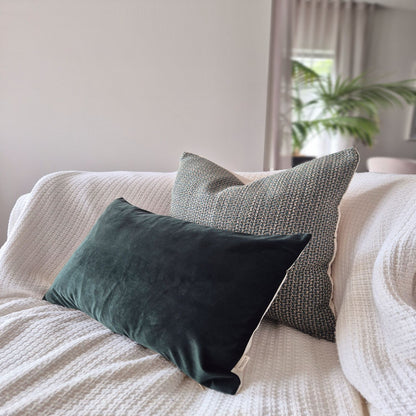 Decorative Threads Emerald Weave cushion cover combo.  Duo of Emerald & Multi-Tonal effect Design, sitting on sofa with a white blanket with a palm plant in the background.