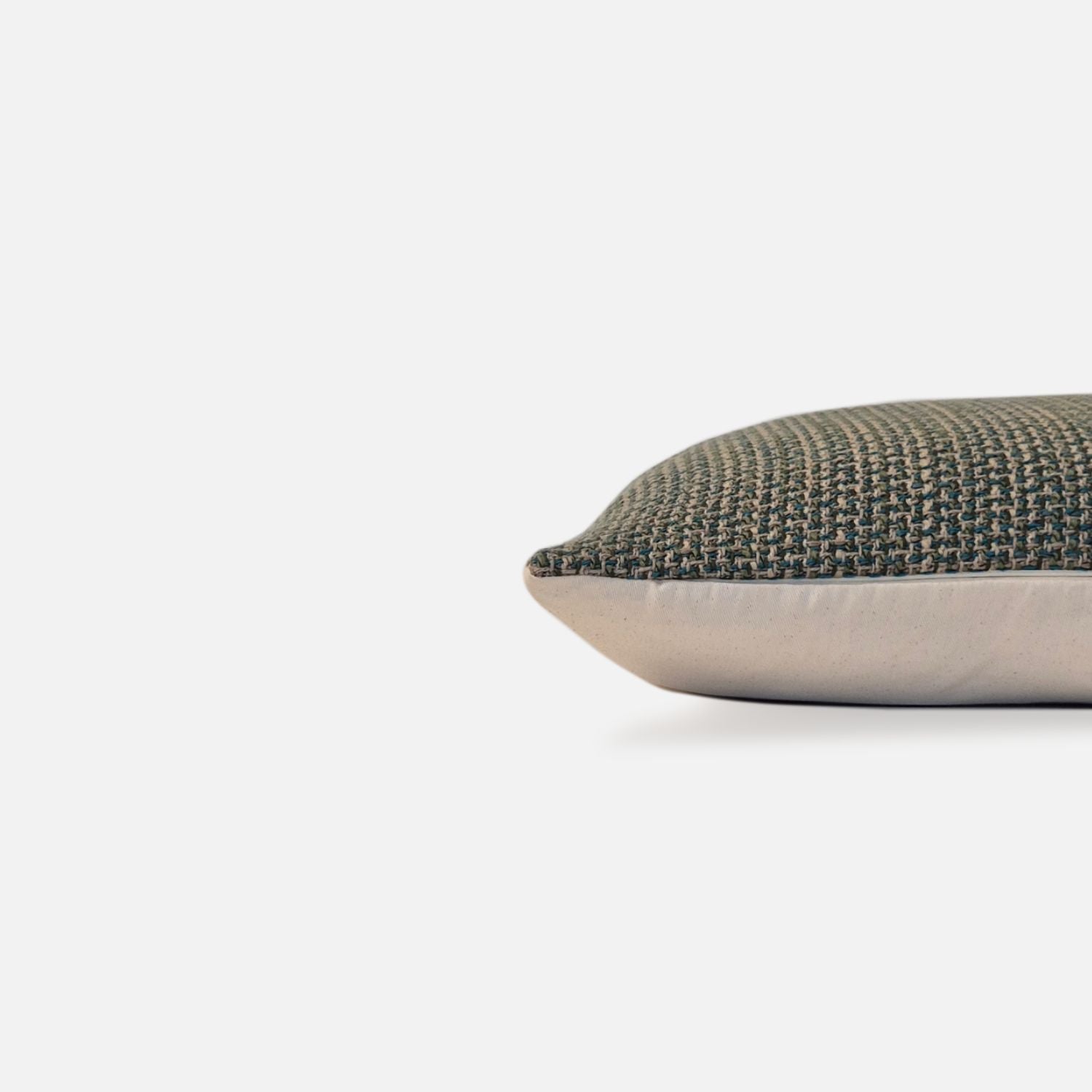 Decorative Threads Multi-Teal Woven cushion cover, side view on a white background. 