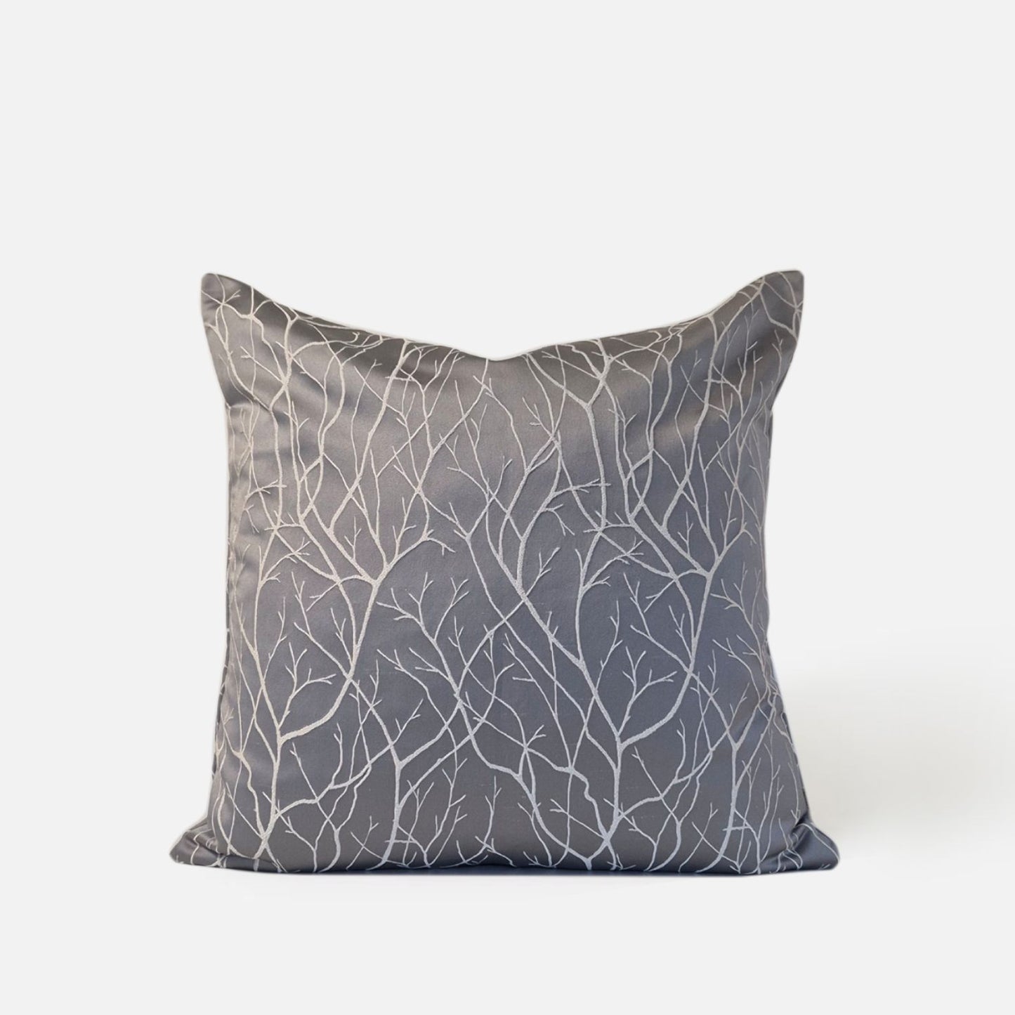 Gray silver cushion with white branch pattern, front view on a white background