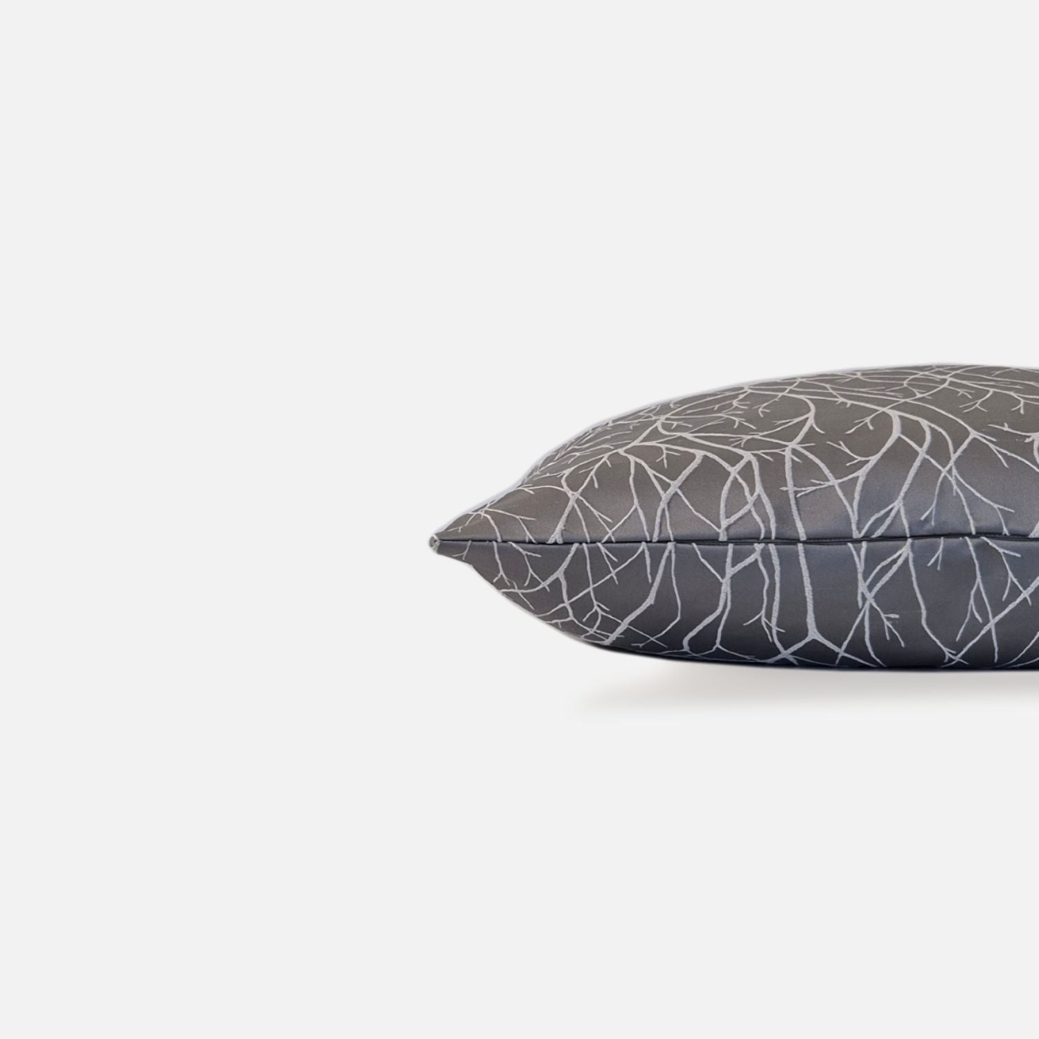 Gray silver cushion with white branch pattern, side view on a white background