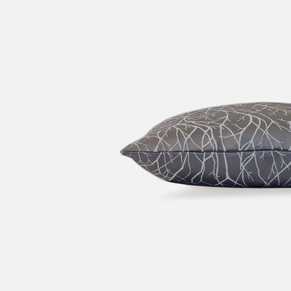 Gray silver cushion with white branch pattern, side view on a white background