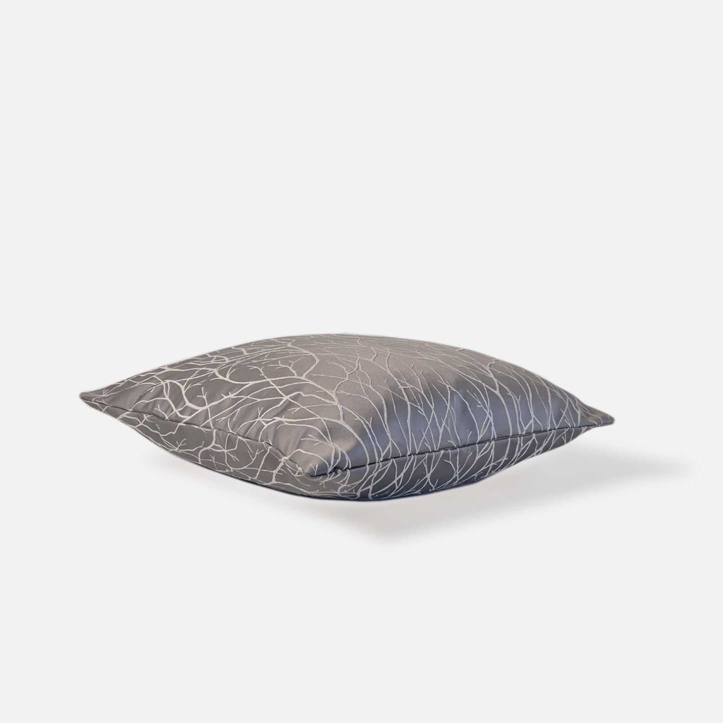 Gray silver cushion with white branch pattern, top view on a white background