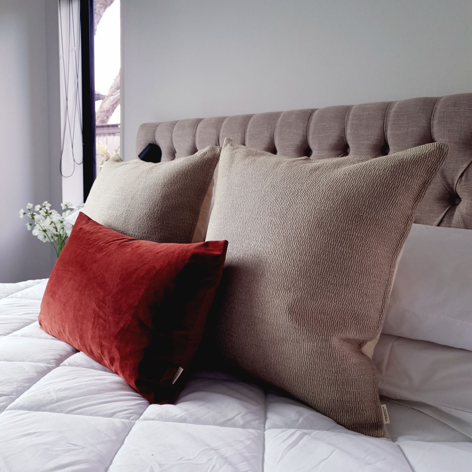 Decorative cushions on a bed with a neutral color scheme