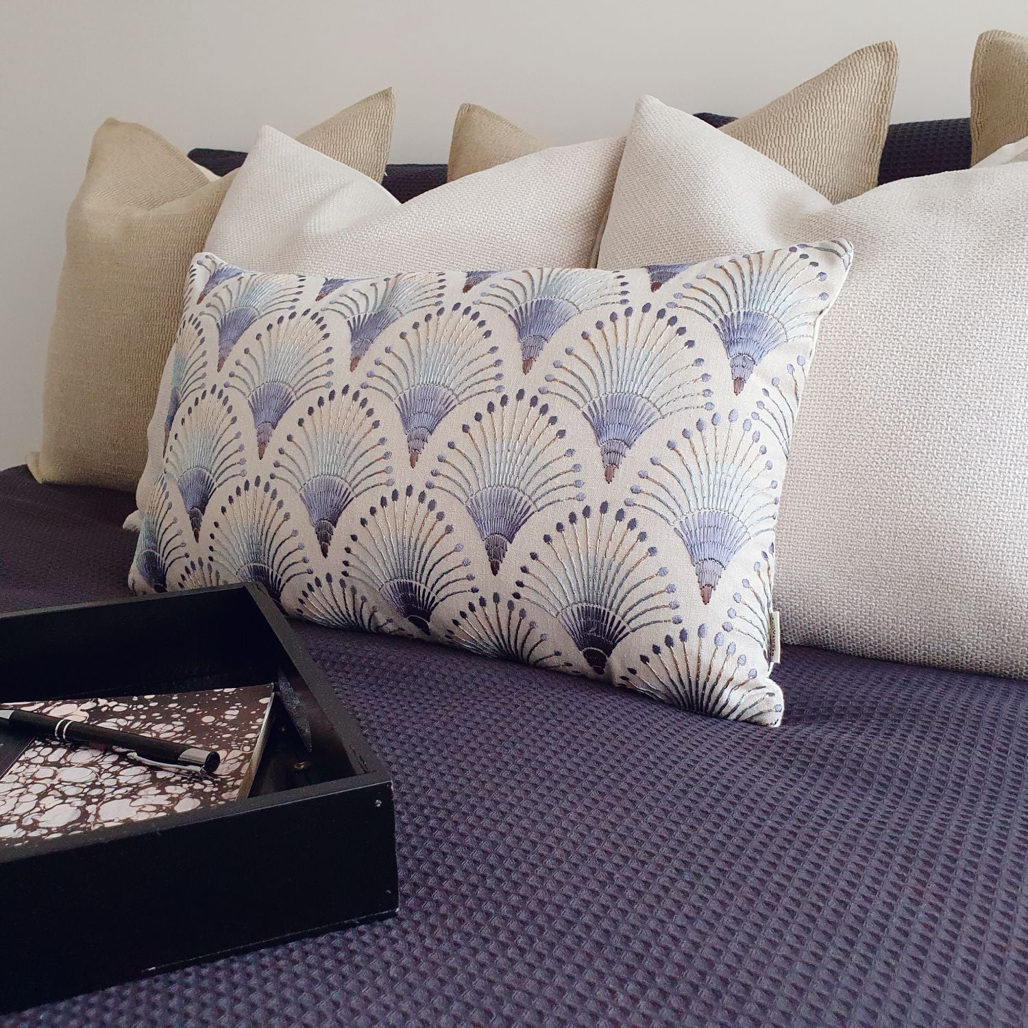 Decorative Threads neutral and embroidered cushions on a bed. Featured Katama, Ida and fanciful. 