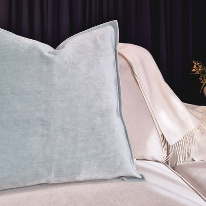 Decorative Threads Omega duckegg cushion on a sofa with a dark curtain background