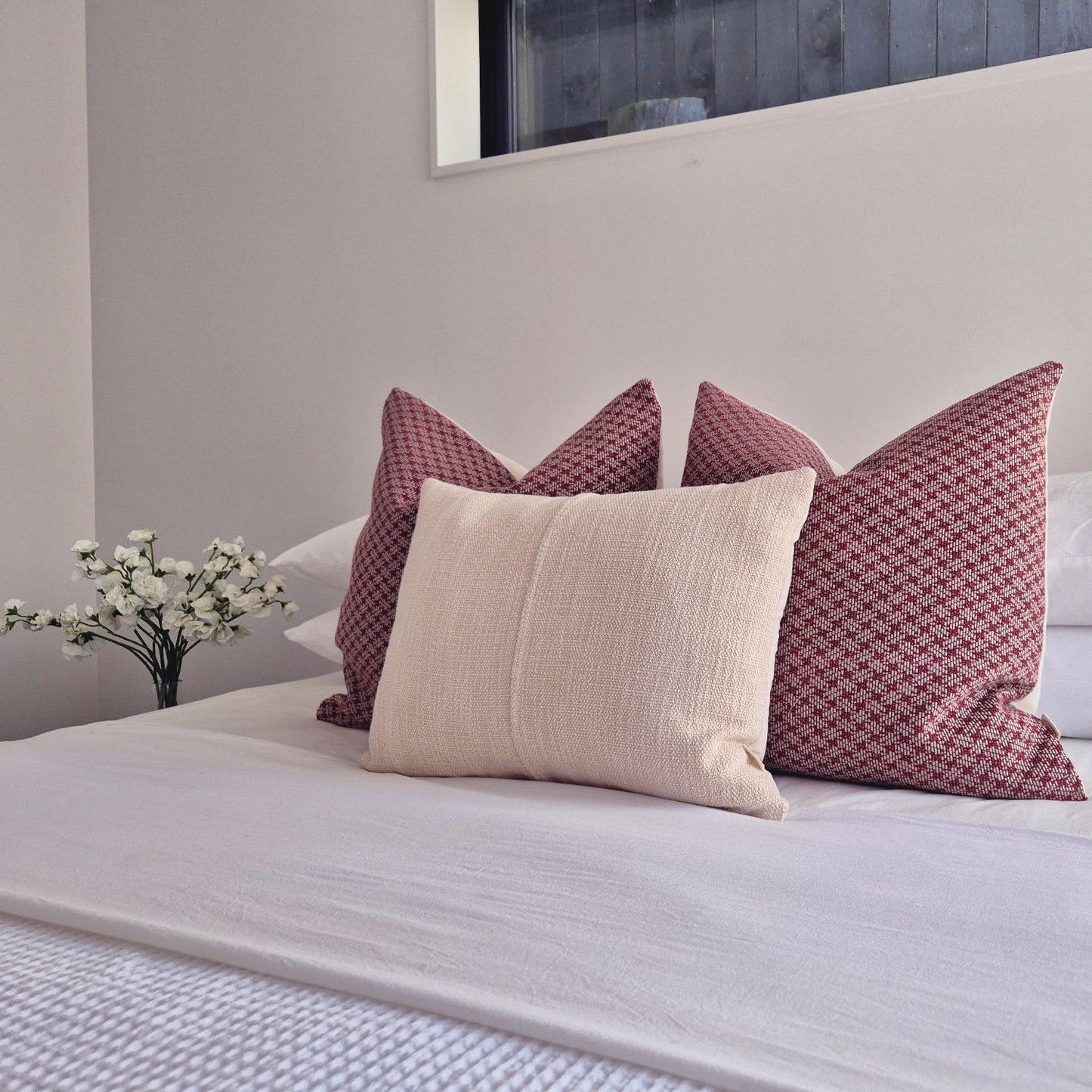 Decorative Threads Scarlet Serenity cushion cover combo. Trio of Geometric and Textured Woven Covers on a bed in a neutral background.