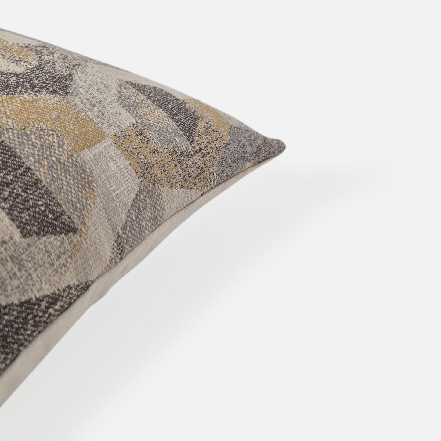 Close-up detail of a textured geometric woven cushion cover in neutral tones.