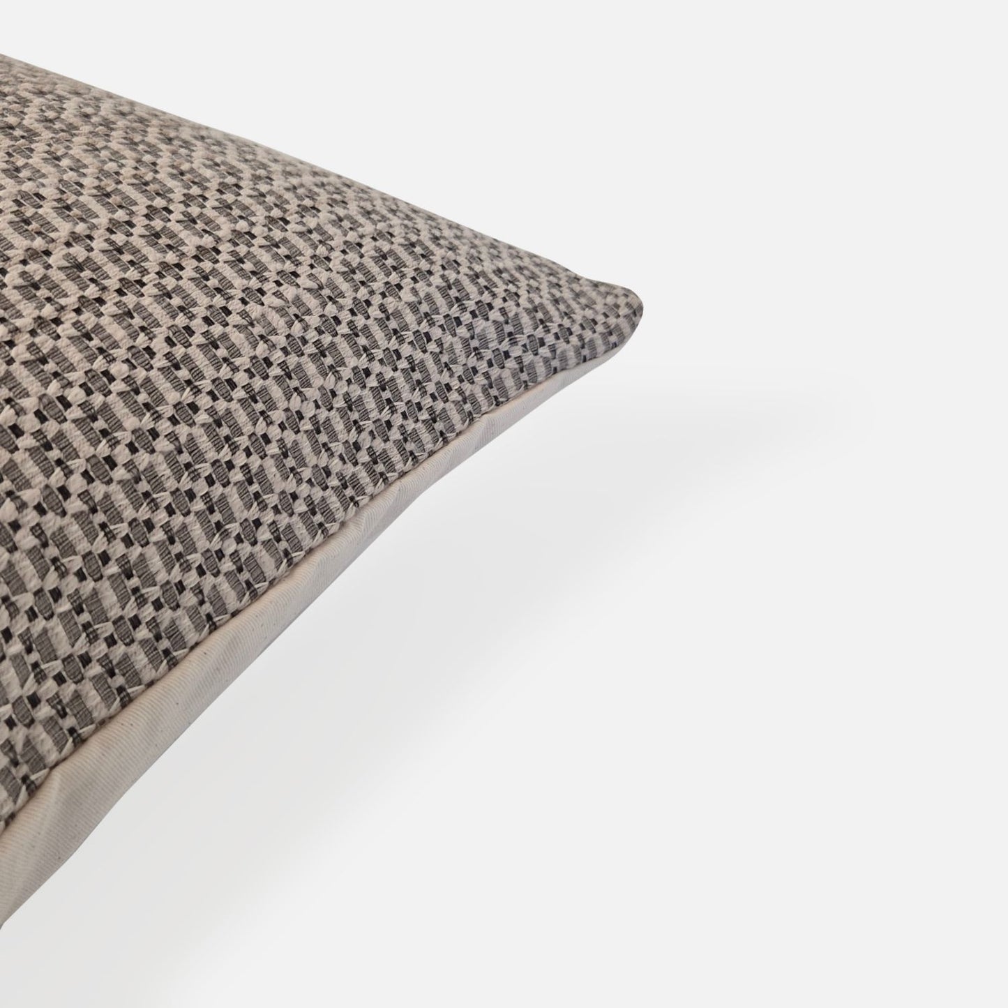 Decorative Threads Textured cushion with a geometric pattern, corner view on a white background.