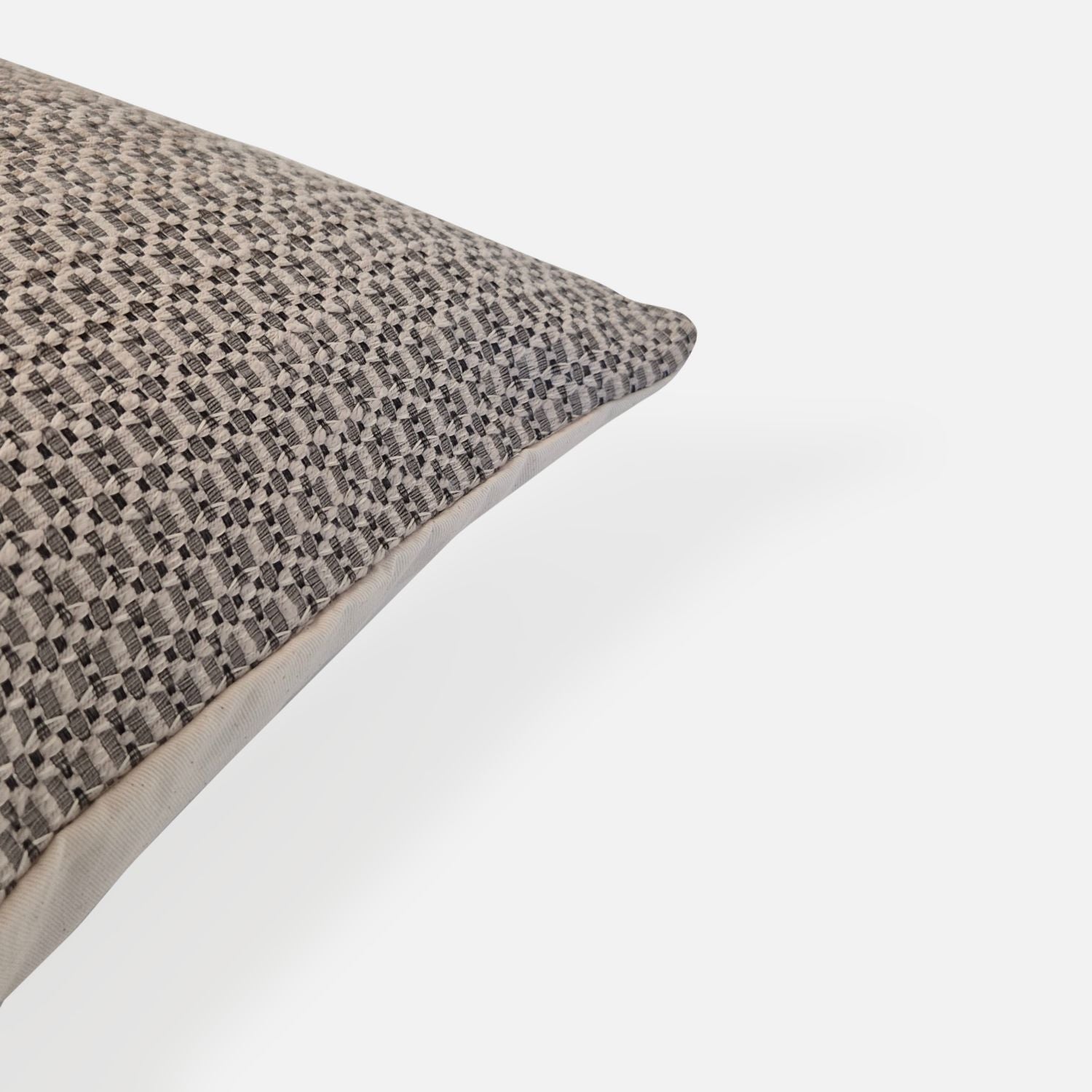 Decorative Threads Textured cushion with a geometric pattern, corner view on a white background.