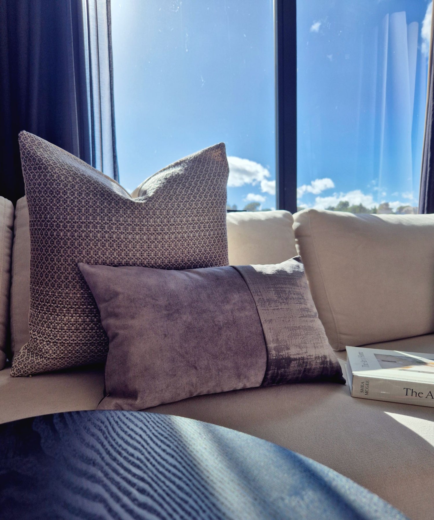 Decorative Threads cushion combo on a sofa with a window view.