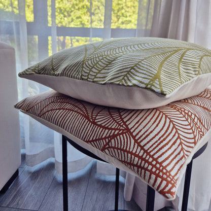 Decorative Threads two veined patterned cushions on a stool with a blurred outdoor background